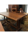 Brown wood antique Indonesian dining table on rustic floor, surrounded by vintage furniture and matching chair.
