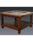 Brown wooden Indonesian table with lower shelf, Dutch Colonial style, on plain gray background.