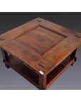 Brown wood square coffee table with rustic finish, handcrafted grain, and lower shelf, Indonesian antique style.