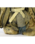 Close-up of an antique Japanese Edo samurai doll in faded fabric clothing with frayed edges and visible stitching.