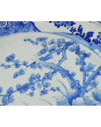 Close-up of white floral and branch patterns on ceramic Japanese hand painted plate.