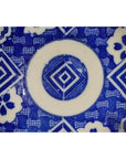 Blue and white ceramic Igezara transferware plate with geometric diamond and floral motifs, close-up.