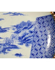 Blue and white ceramic Japanese Igezara plate with landscape, trees, river, and geometric rim design.