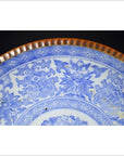 Close-up of blue and white ceramic Japanese Igezara plate with floral patterns and ridged brown glazed edge.