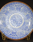 Blue and brown porcelain Igezara transferware plate with ornate floral pattern, displayed on gold stand.