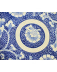 Blue and white porcelain Igezara transferware plate with floral and leaf concentric patterns, close-up view.