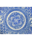 Blue and white ceramic Igezara transferware plate with intricate floral and geometric designs, close-up.