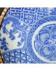 Close-up of blue and white porcelain Igezara plate with floral and geometric patterns, gold trim, antique Japanese style.