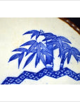 Blue and white porcelain Igezara plate with bamboo and geometric Asian motifs, transferware design, close-up.