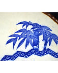 Blue and white porcelain Igezara plate with bamboo and geometric Asian motifs, transferware design, close-up.
