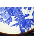 Close-up of blue and white porcelain Japanese Igezara transferware plate on brass stand.