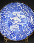 Blue and white porcelain Igezara plate with intricate floral patterns on a decorative stand.