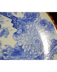 Close-up of blue and white porcelain Igezara Japanese plate with floral patterns and brown rim.