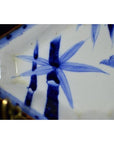 White and blue porcelain Imari bowl with hand painted bamboo, leaves, and small bird design, close-up view.