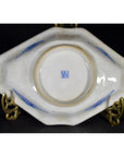 Bottom view of blue and white porcelain Imari bowl with hand painted accents and seal mark, displayed on gold stand.