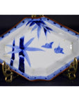 Blue and white porcelain Imari bowl with hand painted bamboo and birds, displayed on a metal stand.