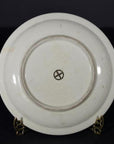 Blue and white porcelain Imari plate back with circular mark and cross, displayed on brass stand.