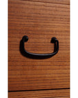 Close-up of black metal handle on antique Japanese Kiri wood chest with horizontal grain and modern design.