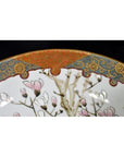 Close-up of an antique Japanese Kutani porcelain bowl with pink flowers and ornate gold, blue, and red hand-painted border.