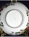 Close-up of the underside of an antique Japanese Kutani hand-painted porcelain bowl on a decorative gold stand.