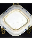 Close-up of an antique Japanese Kutani hand painted porcelain dish base on a metal stand against a dark background.