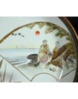 Antique Japanese Kutani porcelain plate with red sun, two figures in traditional attire by the sea.