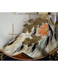 Close-up of an antique hand painted Japanese Kutani porcelain plate with orange flower and gold leaves.
