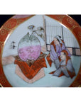 Close-up of an antique Japanese Satsuma porcelain plate with two figures and a large peach, hand painted, multicolor.