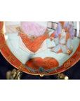 Close-up of an antique Japanese Satsuma porcelain plate with intricate hand-painted scene and seated figure.