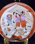 Colorful ceramic Satsuma plate with samurai in robes battling near a building with flying arrows, close-up view.