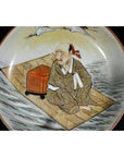 Antique Japanese Satsuma porcelain plate featuring a man in patterned robes with red box, hand painted design.