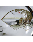Porcelain plate with hand painted fan scene of two by sea, birds, and red sun, Taisho era, light wear visible.