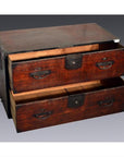 Brown wooden Japanese Tansu cabinet with metal handles and two open drawers, worn finish, close-up view.