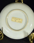 White porcelain Japanese transferware plate with "JAPAN" mark displayed on a decorative metal stand.