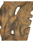 Brown wood Burmese temple carving, mirrored guardian relief with intricate headgear and expressive details, close-up.