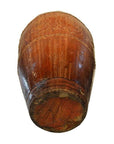 Brown wooden Martaban water jar with visible grain and carved floral patterns, bottom view.