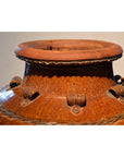 Close-up of a brown ceramic water jar with textured patterns and sturdy rim handles.
