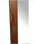 Close-up of silver metal mortise lock and rectangular cutout on antique mirror edge against white background.