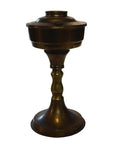 Brass oil lamp with antiqued finish, wide base, slender stem, and lidded container, classic decor style.