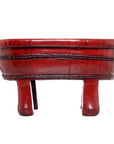 Close-up of antique red wooden basin with round shape, three short legs, red lacquer finish, and woven detailing.