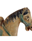 Close-up of a glazed terracotta Ming Dynasty horse with faded paint and green harness.