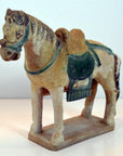 Green glazed terracotta Ming Dynasty horse with saddle on rectangular base, close-up.