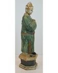 Green terracotta court figure statue from Ming dynasty wearing hat, on hexagonal base.