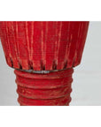 Close-up of red ribbed wooden leg from an antique Thai ceremonial drum with round base.