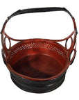 Close-up of a round red and black Antique Thailand basket with handle and cutout design, woven for storage.