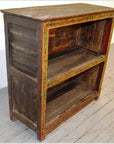 Brown wooden Tibetan bookshelf with two shelves, featuring a faded hand-painted floral border on the front edges.