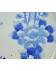 Blue and white porcelain plate with hand painted floral and insect design, close-up view.