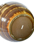 Close-up of a large ceramic vase with earth tones glaze, label visible on the bottom.