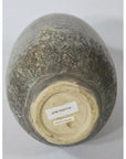Close-up bottom view of brown ceramic Artisan vase with two labels, one reading "MADE IN THAILAND.