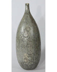 Close-up of large ceramic vase with narrow neck, mottled gray textured surface, set against a plain background.
